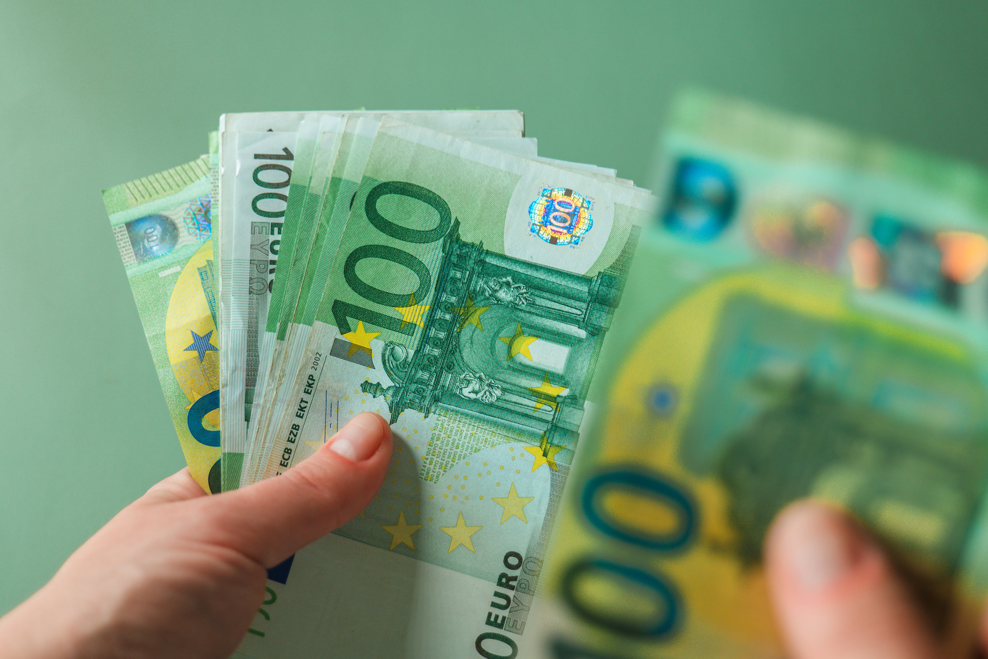 10 Fun Facts zum Thema Geld Eine Person zählt 100-Euroscheine